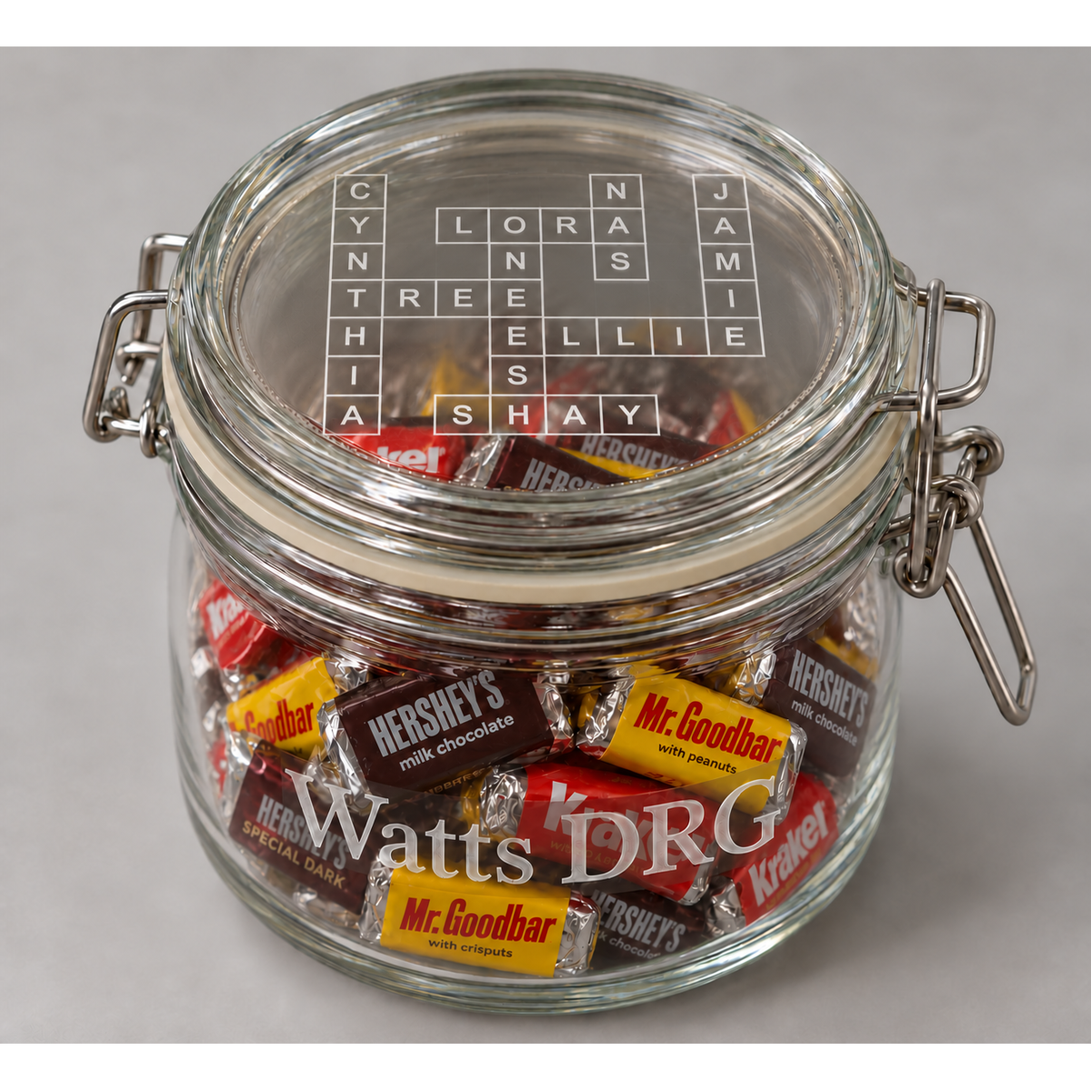 Watts DRG engraved candy jar with eight-name crossword including Cynthia and assorted Hershey's miniatures.